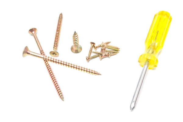 Different yellow screwdriver and golden screws — Stock Photo, Image