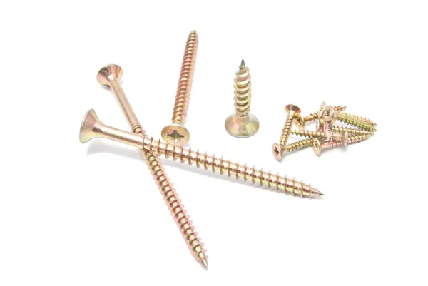 Many different golden screws on white — Stock Photo, Image