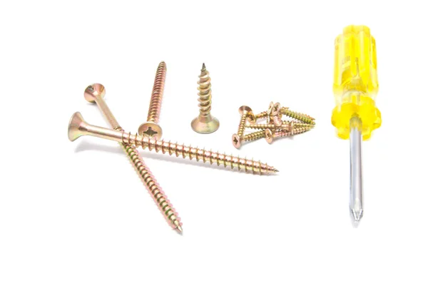 Yellow screwdriver and golden screws — Stock Photo, Image