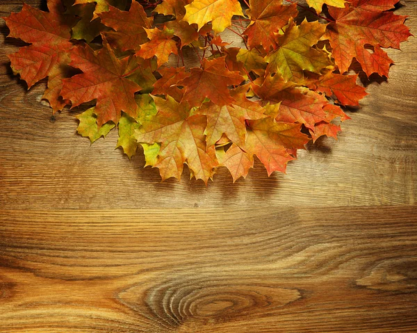 Arka planda sarı nemli sonbahar yaprakları koyu eski bir ahşap