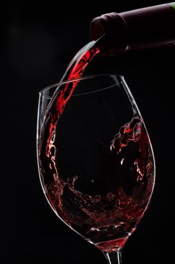 kırmızı şarap bardağa döküldü.