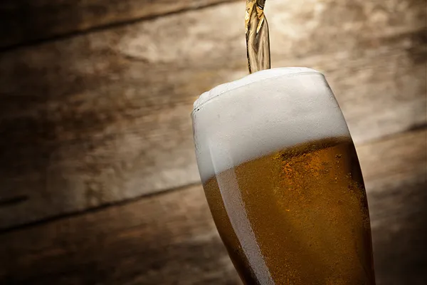 Skleněné pivo na dřevěném pozadí s kopírovacím prostorem — Stock fotografie