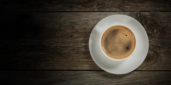 棕色背景上的木桌上杯热咖啡 — 图库照片