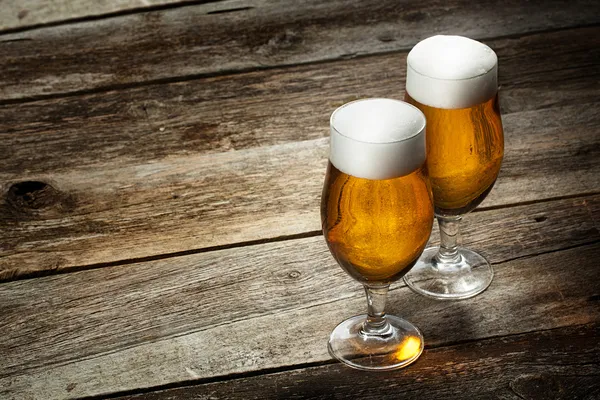 两个玻璃啤酒与 copyspace 木背景上 免版税图库照片