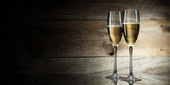 dvě skla s šampaňským na dřevěné pozadí