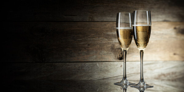 Two glass with champagne on a wooden background