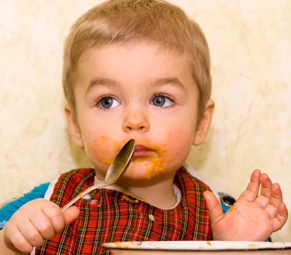 Niedlicher kleiner Junge, der Kürbis isst — Stockfoto