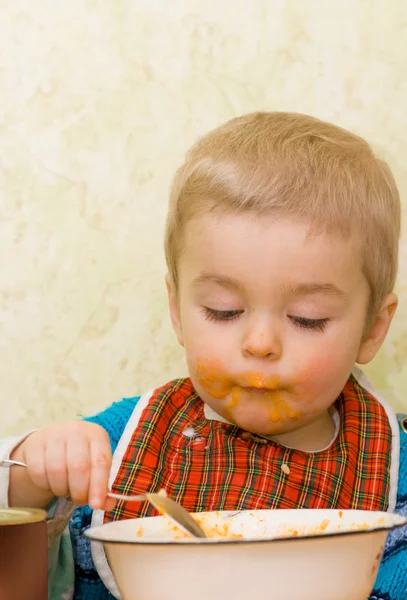 Niedlicher kleiner Junge, der Kürbis isst — Stockfoto