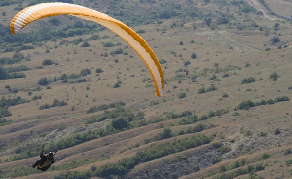 在谷之上的橙色滑翔伞 — 图库照片#