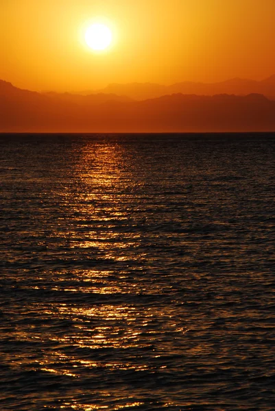 Zonsopgang op de zee met hoge bergen — Stockfoto