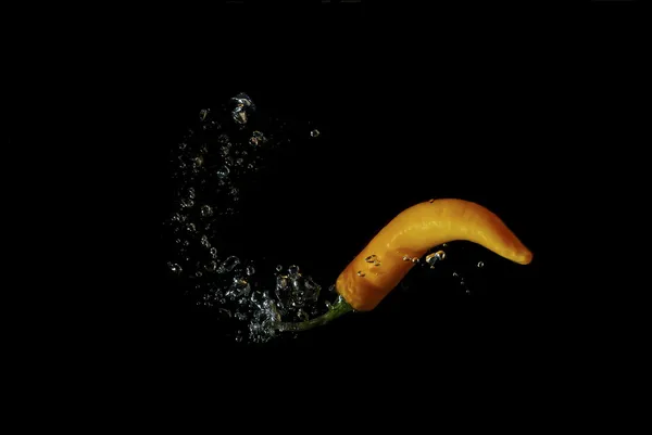 Oranje peper in water en belletjes — Stockfoto