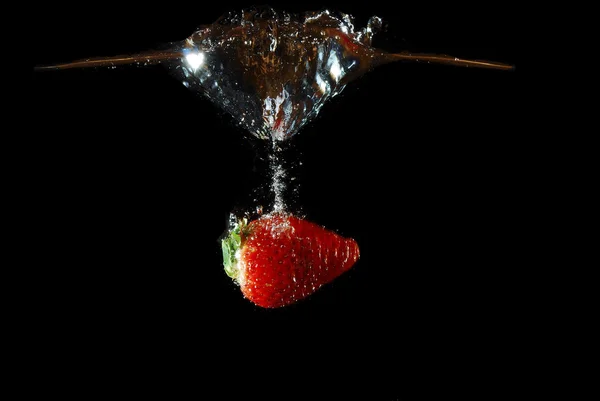 Strawberry falling into water with lane — Stock Photo, Image