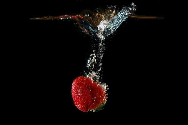 Fragola cade rapidamente in acqua — Foto Stock