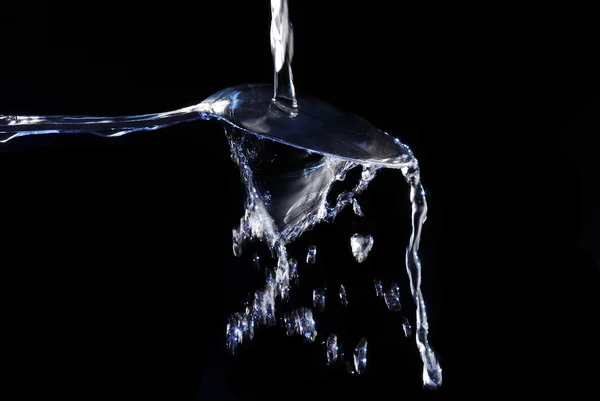 Spoon with splashing water — Stock Photo, Image