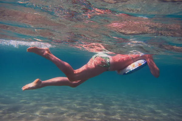 Kvinna i bikini flytande i havet — Stockfoto