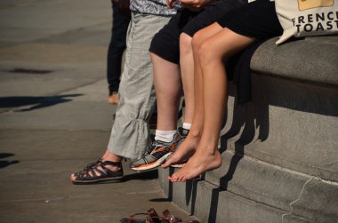 people sitting on fountain in city
