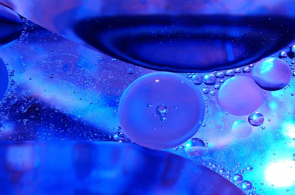 Óleo na superfície da água azul — Fotografia de Stock
