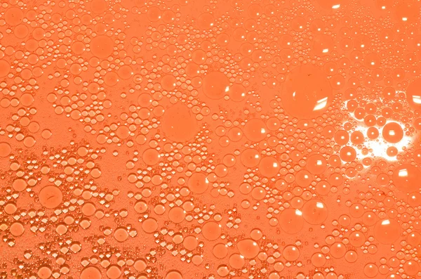 Масло в оранжевой воде — стоковое фото
