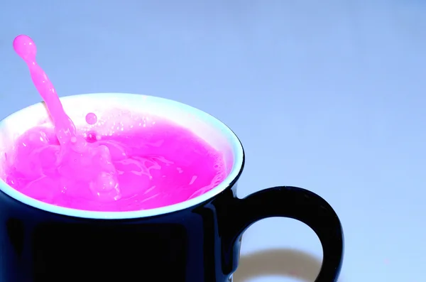Black cup with pink liquid — Stock Photo, Image