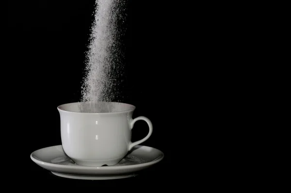 Sugar trickles into cup — Stock Photo, Image