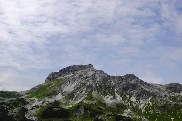 Högt Stenigt Berg Med Lite Snö Toppen Med Mjuka Moln — Stockfoto