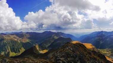 Renkli bir dağ sırasına ve mavi gökyüzünde beyaz bulutlara muhteşem bir manzara.
