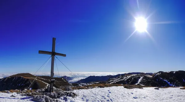 雪と輝く太陽のパノラマの山から山頂を横切る木製の山頂 — ストック写真