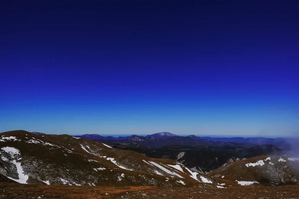 Wijds Uitzicht Een Bergketen Met Sneeuwvelden Diepblauwe Lucht Tijdens Het — Stockfoto