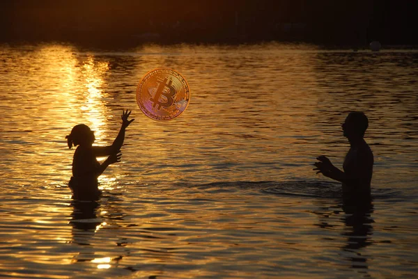 Ζευγάρι Παίζει Μπάλα Ένα Bitcoin Στο Νερό Στο Ηλιοβασίλεμα Εικόνα Αρχείου