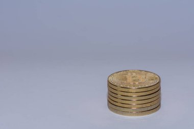 Kripto para biriminden gri arkaplanlı bir yığın altın değerli bitcoin.