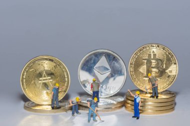 Değerli şifreli paralar Bitcoin eter ve arka arkaya gri arka planda birçok işçiyle birlikte.