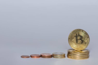 Gri arkaplan içinde üst üste dizilmiş kripto para biriminden avro sikkeleri ve bitcoinler