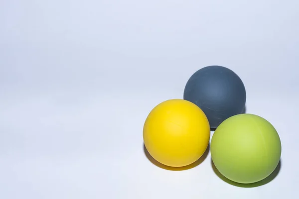 三个不同颜色的球 在灰色背景下按摩 — 图库照片