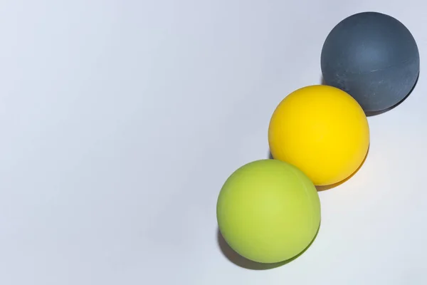 三个不同颜色的球 在灰色背景对角线上连续按摩 — 图库照片