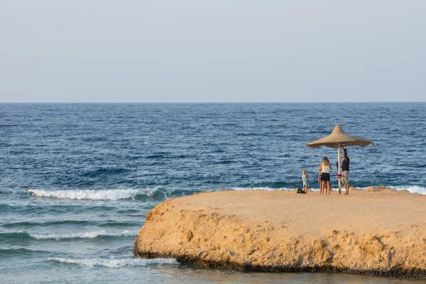 全家人在一个海滩的伞下 在海湾上的一个海景下的埃及细景 — 图库照片