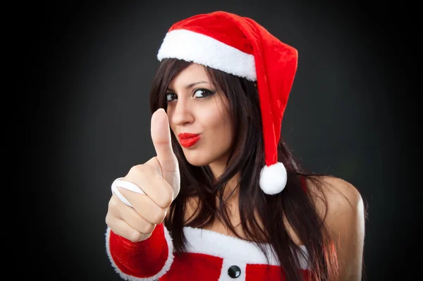 Noel Baba kıyafetlerle bir ok işareti veren kız — Stok fotoğraf