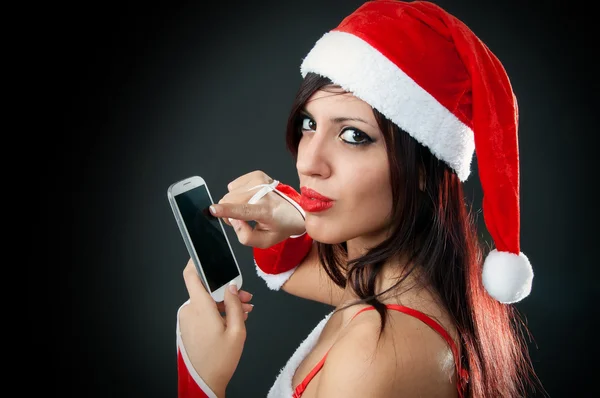 Dívka, která nosí santa claus oblečení s smartphone — Stock fotografie