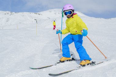 Skiing, skiers on ski run - child skiing downhill clipart