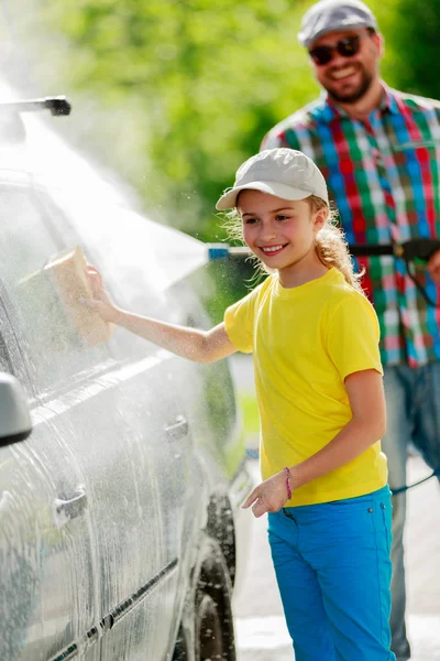 Autowaschanlage - junges Mädchen mit Vater in Autowaschanlage. — Stockfoto