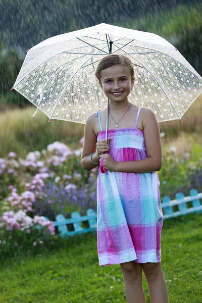 Sommarregn - glad tjej med ett paraply i regnet — Stockfoto