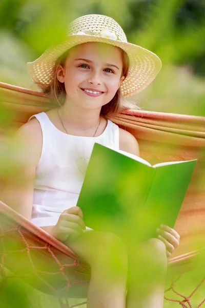 Alegria de verão, rede - menina com um livro que descansa em uma rede — Fotografia de Stock