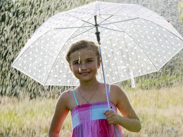 Sommarregn - glad tjej med ett paraply i regnet — Stockfoto