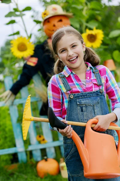 Fågelskrämman och glad tjej i trädgården — Stockfoto