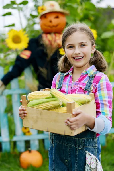Scarecrow and happy girl in the garden — Stock Photo, Image