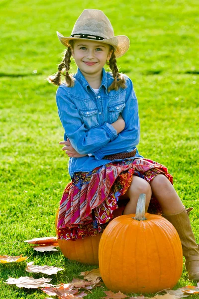 Herfst oogst - lief meisje en grote pompoenen — Stockfoto