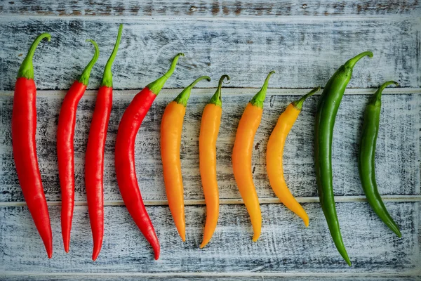 Fresh chili peppers on wooden board — Stock Photo, Image