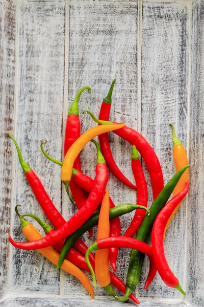 Fresh chili peppers on wooden board — Stock Photo, Image