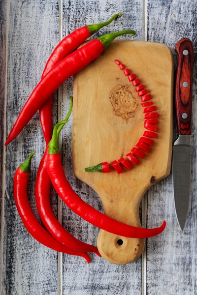 Fresh chili peppers on wooden board — Stock Photo, Image