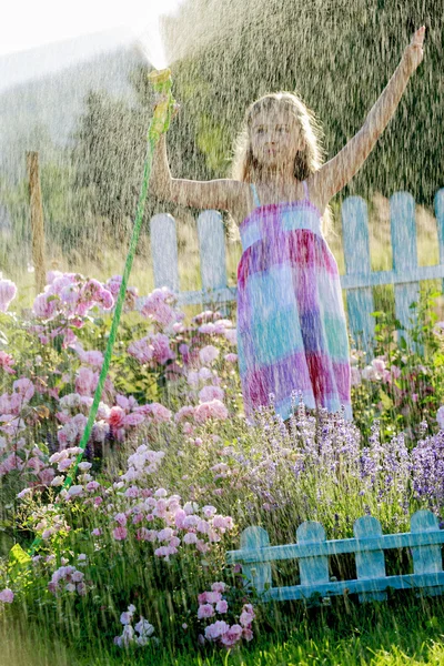 De pret van de zomer, meisje drenken bloemen — Stockfoto