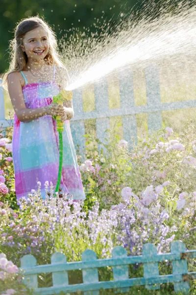 夏の楽しみ、花に水をまく少女 — ストック写真